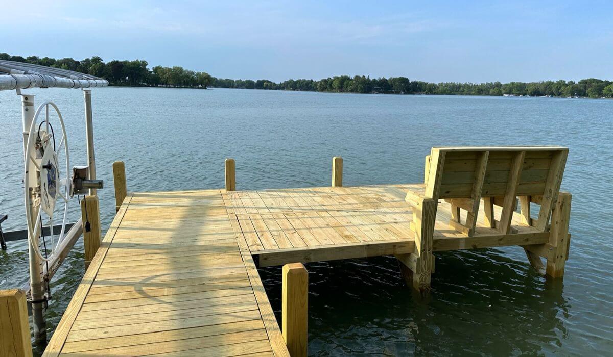 L shape wood dock featuring a wood bench on Lac La Belle in Lake Country Wisconsin.